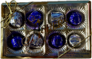 A gold box tied with a ribbon contains eight sugar-free cherry cordials, each wrapped in shiny blue foil, showcasing a premium chocolate gift suitable for special occasions.